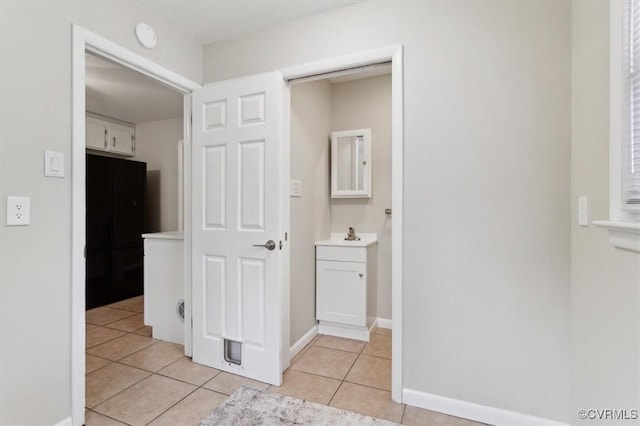 bathroom with baseboards, vanity, and tile patterned flooring