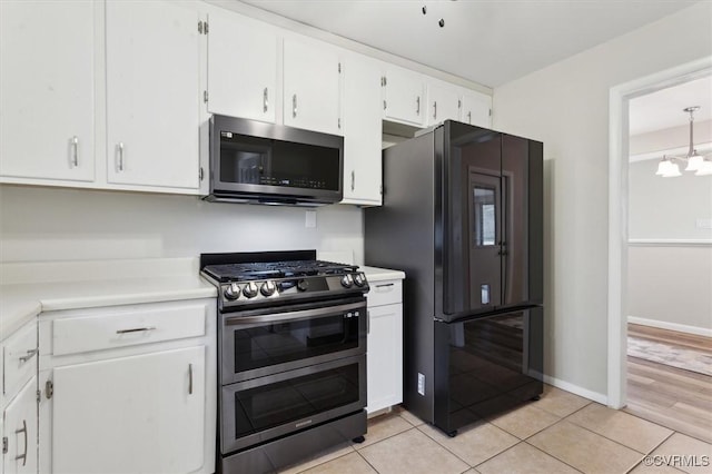 kitchen with white cabinetry, light countertops, light tile patterned floors, and stainless steel appliances