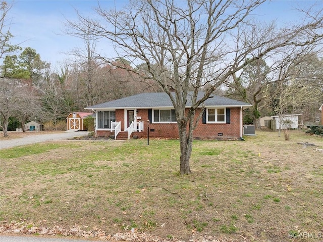 single story home with brick siding, a front lawn, a shed, crawl space, and an outbuilding