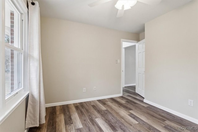 empty room with a wealth of natural light, ceiling fan, baseboards, and wood finished floors