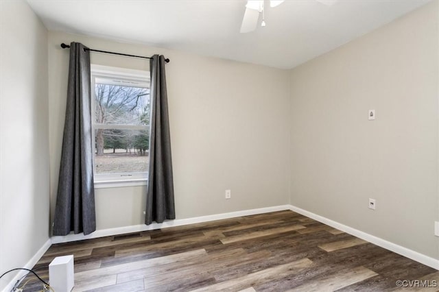 spare room with baseboards, wood finished floors, and a ceiling fan