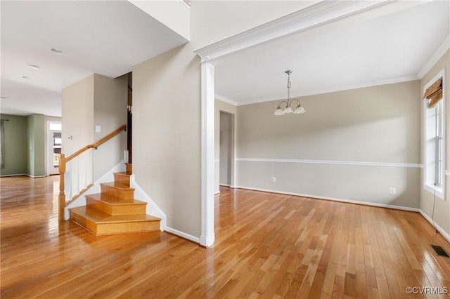 interior space with visible vents, crown molding, a chandelier, stairway, and light wood-type flooring