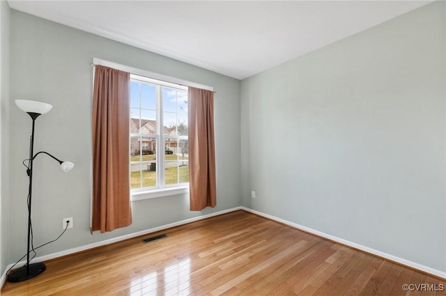 unfurnished room featuring visible vents, baseboards, and light wood-style floors