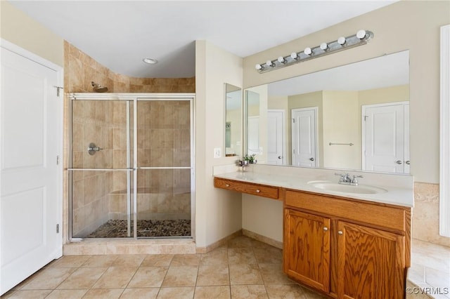 bathroom featuring tile patterned floors, a stall shower, vanity, and baseboards