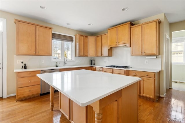 kitchen featuring dishwasher, plenty of natural light, gas stovetop, and a sink