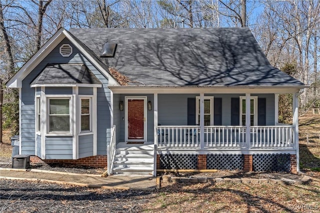 view of front of house featuring covered porch and a shingled roof