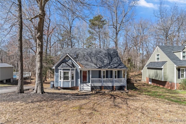 view of front of house with covered porch and a shingled roof