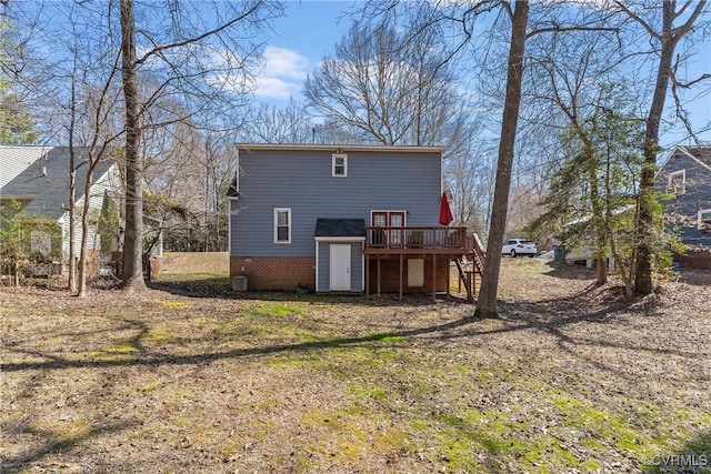 rear view of house featuring brick siding, a deck, and stairs