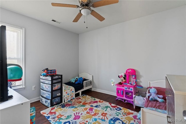 bedroom featuring ceiling fan, visible vents, baseboards, and wood finished floors