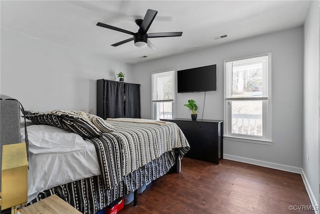 bedroom featuring a ceiling fan, wood finished floors, visible vents, and baseboards