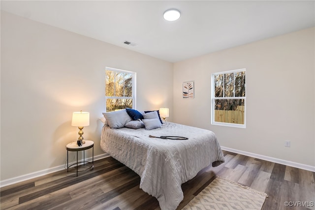 bedroom featuring visible vents, baseboards, and dark wood finished floors