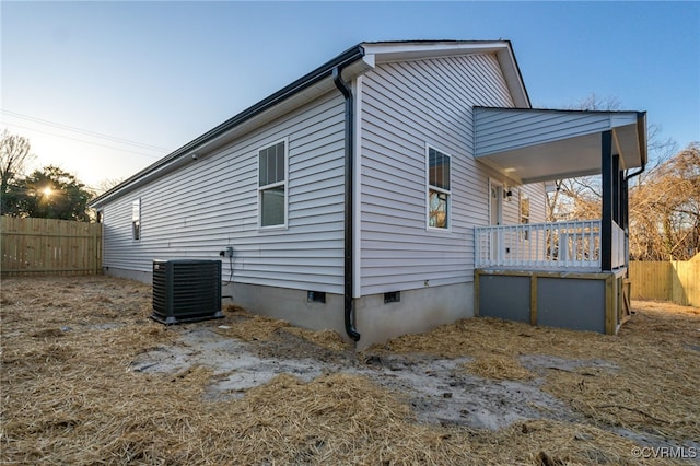 view of home's exterior with crawl space, covered porch, cooling unit, and fence