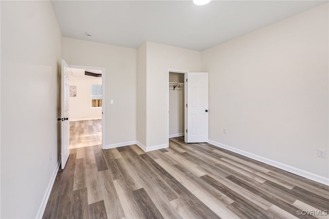 unfurnished bedroom featuring a closet, baseboards, and wood finished floors