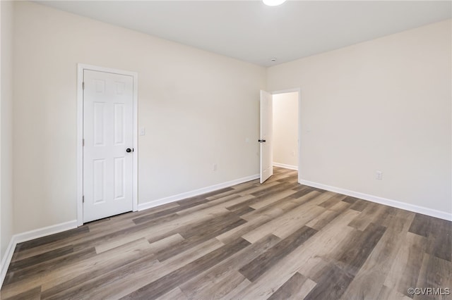 empty room with baseboards and wood finished floors