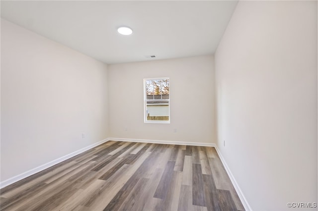 unfurnished room with wood finished floors and baseboards