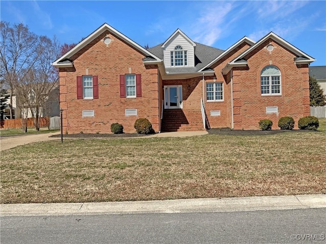 view of front of property with crawl space, a front yard, brick siding, and fence