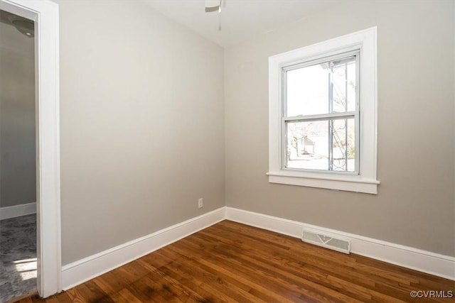 spare room with visible vents, baseboards, a ceiling fan, and dark wood-style flooring