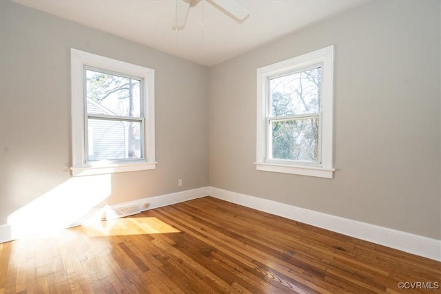 spare room with a ceiling fan, baseboards, and hardwood / wood-style floors