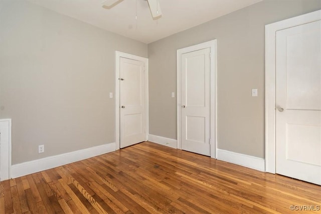 unfurnished bedroom featuring ceiling fan, baseboards, and hardwood / wood-style floors