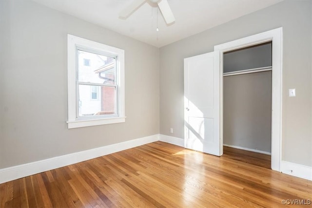 unfurnished bedroom with a closet, ceiling fan, light wood-type flooring, and baseboards