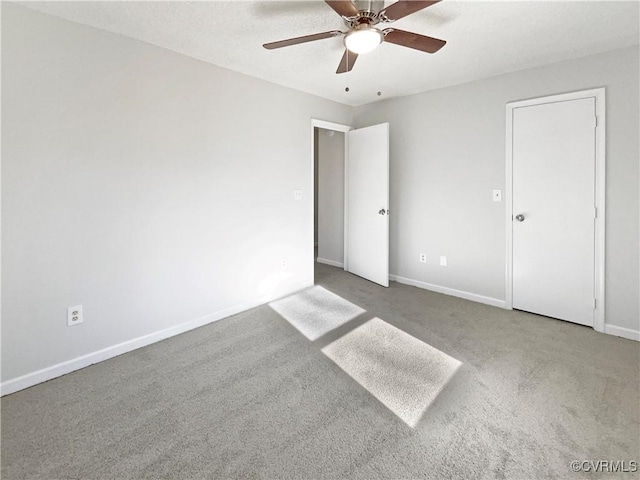 unfurnished bedroom with carpet flooring, a ceiling fan, and baseboards