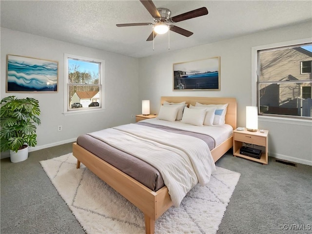 carpeted bedroom featuring visible vents, baseboards, a textured ceiling, and a ceiling fan