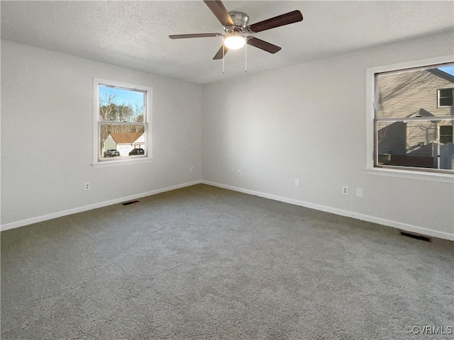 carpeted spare room with visible vents, baseboards, a textured ceiling, and ceiling fan