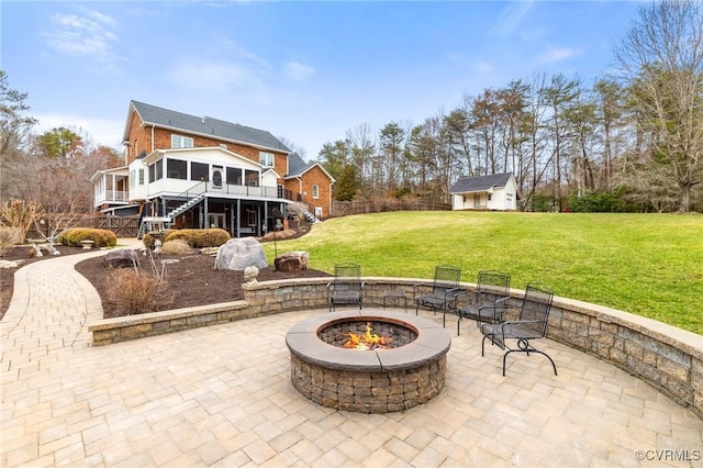 view of patio / terrace featuring stairway, a wooden deck, a sunroom, an outdoor structure, and a fire pit