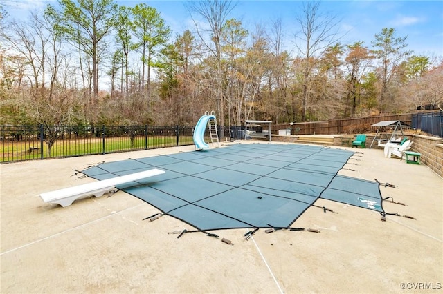 view of swimming pool featuring a fenced in pool, a water slide, a patio, and fence