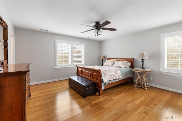 bedroom featuring visible vents, light wood-style flooring, baseboards, and ceiling fan