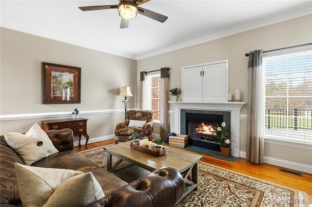 living area featuring visible vents, baseboards, and wood finished floors