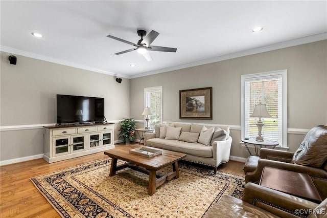 living area featuring baseboards, recessed lighting, ceiling fan, crown molding, and light wood-type flooring