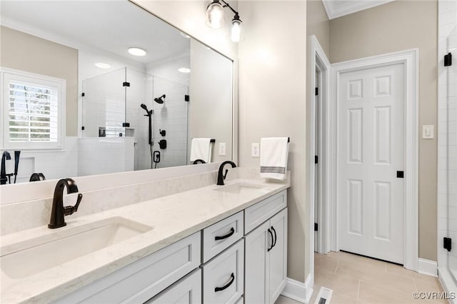 full bathroom with tile patterned flooring, a stall shower, crown molding, and a sink