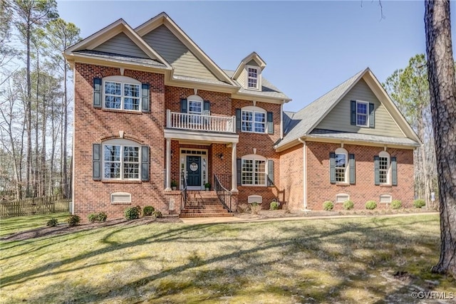 view of front of property with crawl space, a front lawn, a balcony, and brick siding