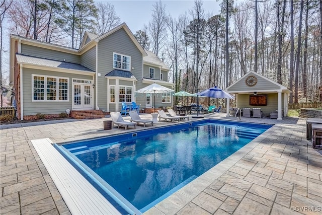 back of house featuring entry steps, a patio, french doors, a fenced in pool, and an outdoor hangout area