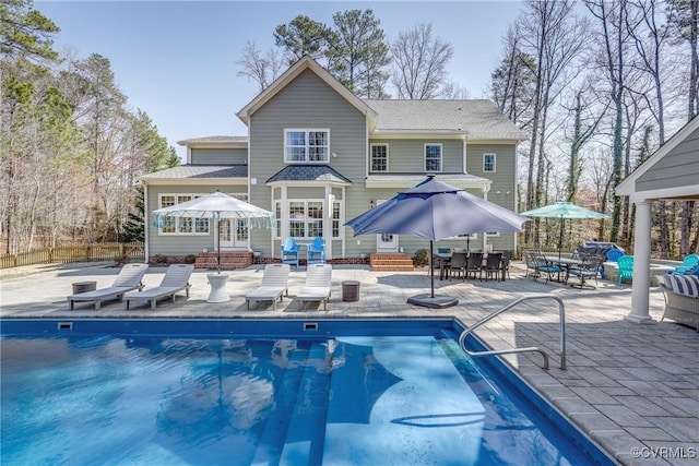 rear view of property with a patio area, a fenced in pool, entry steps, and fence