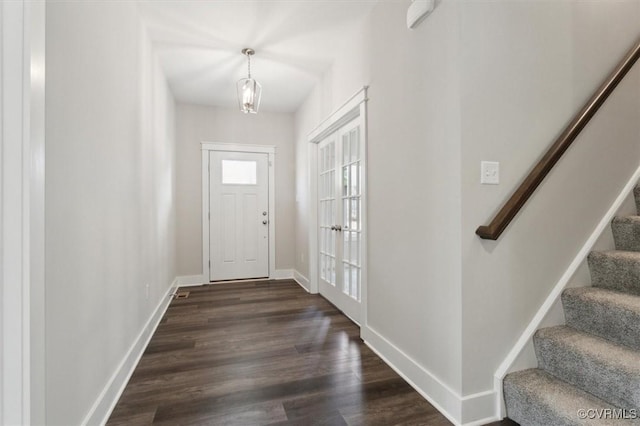 foyer with stairway, baseboards, and dark wood-style flooring