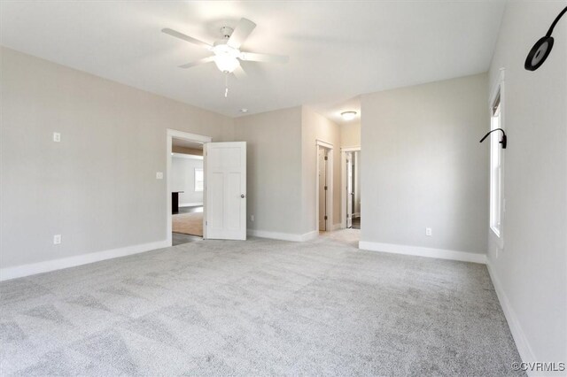 unfurnished bedroom with multiple windows, baseboards, and light colored carpet