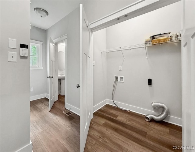 laundry area featuring laundry area, hookup for a washing machine, wood finished floors, and baseboards