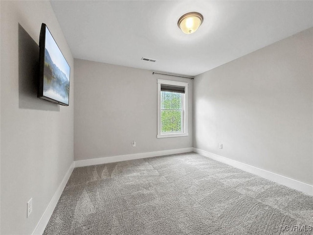 spare room with visible vents, carpet flooring, and baseboards