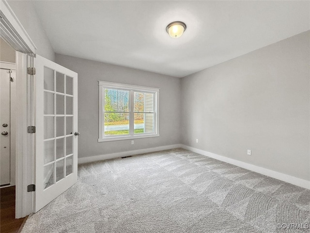 carpeted empty room featuring visible vents and baseboards