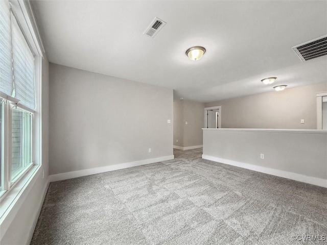 carpeted empty room with visible vents and baseboards