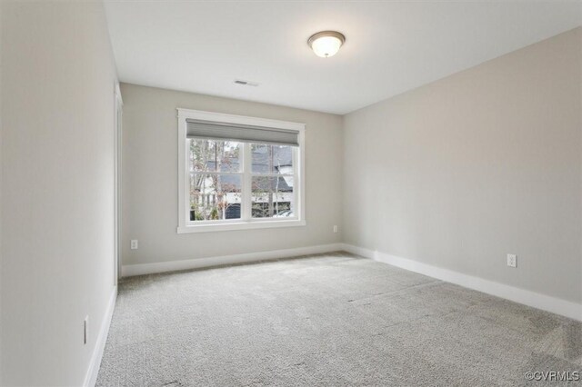 carpeted empty room featuring visible vents and baseboards