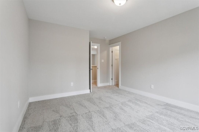 spare room featuring baseboards and carpet floors