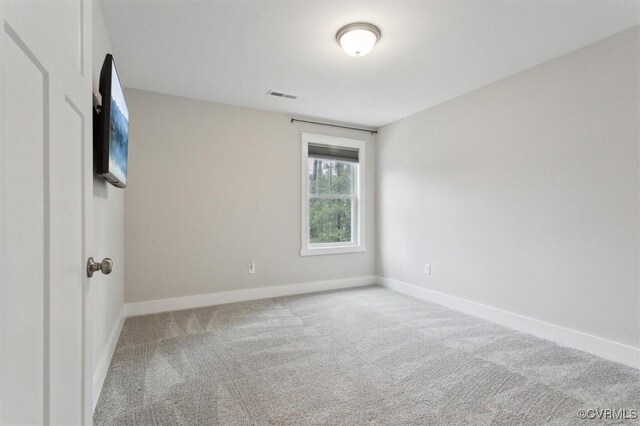 unfurnished room featuring carpet, visible vents, and baseboards