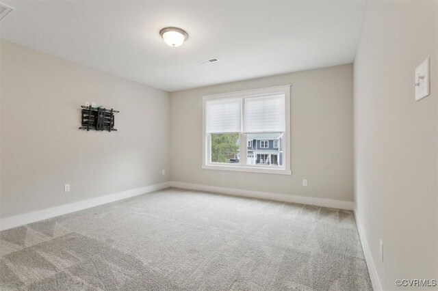 empty room with visible vents, baseboards, and carpet