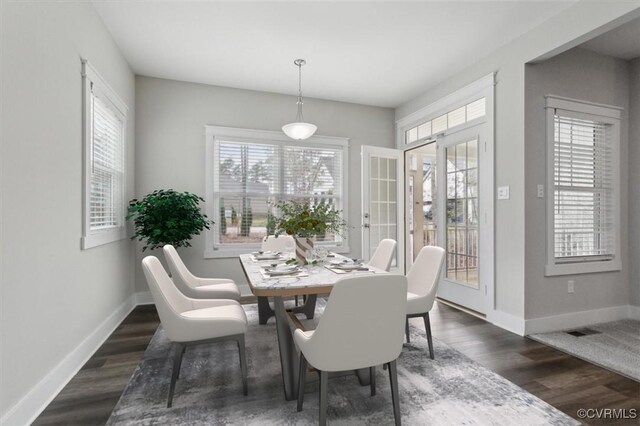 dining area featuring dark wood finished floors, visible vents, and baseboards