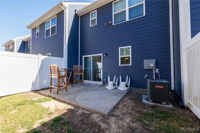 back of house featuring fence, central AC unit, and a patio area