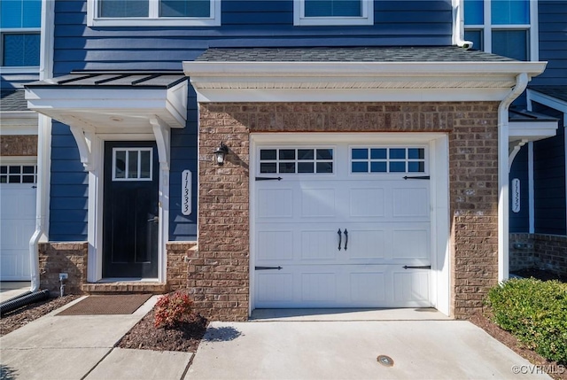 doorway to property with concrete driveway and roof with shingles