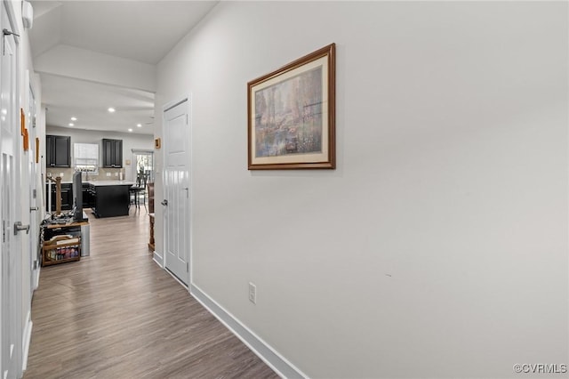 corridor featuring recessed lighting, baseboards, and wood finished floors